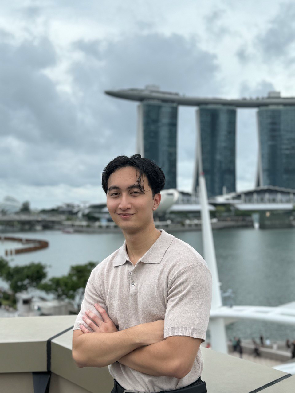 Shank standing with folded arms in front of Marina Bay